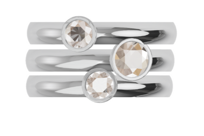 Set of three white gold rings with diamonds on a white background